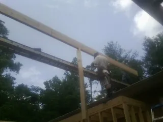 Carpenter setting a ridge beam over a new addition frame — Ice Dam Removal by Roofing Brothers in Siloam