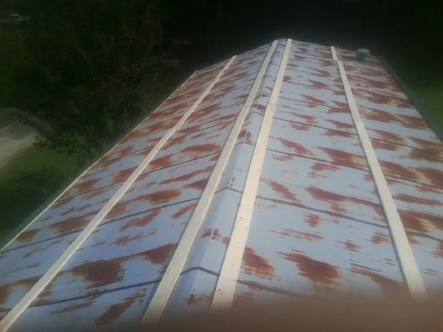 Rusted metal roof panels with new wood purlins before replacement — Storm Damage Roof Repair in Siloam by Roofing Brothers