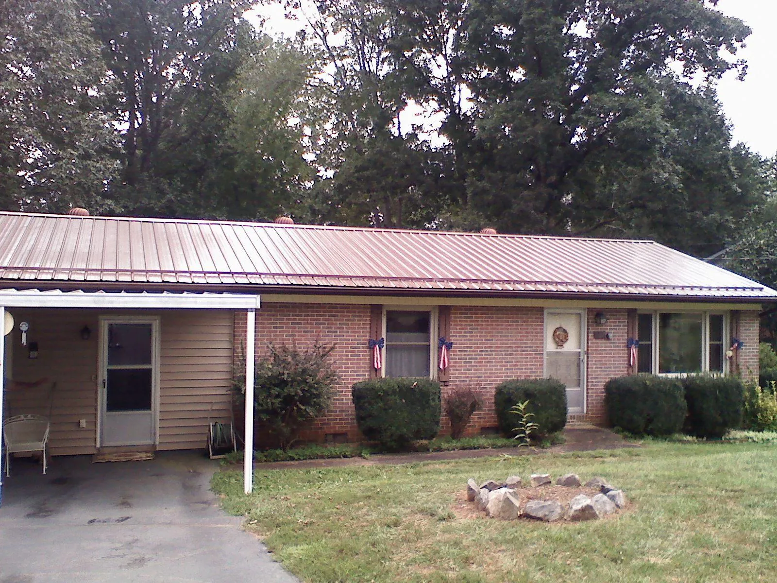 Bronze metal roof and carport on a brick ranch home — Roof Repair work by our crew in Siloam