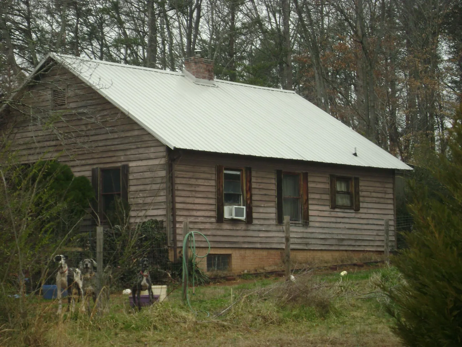 White metal roof on an old wood sided farmhouse, from a Metal Roof Installation job in Siloam